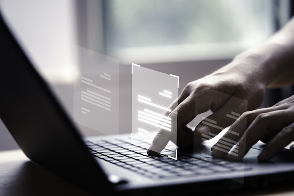 Hand using laptop computer with virtual screen and document for online approve paperless quality assurance and erp management concept (by DilokaStudio)